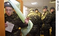 A Ukrainian soldier holds his ballot on leaving the polling booth at a polling station in downtown Kiev, Ukraine, Sunday, March 26, 2006